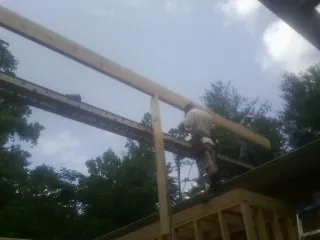 Carpenter setting a ridge beam over a new addition frame — Ice Dam Removal by Roofing Brothers in Sausalito