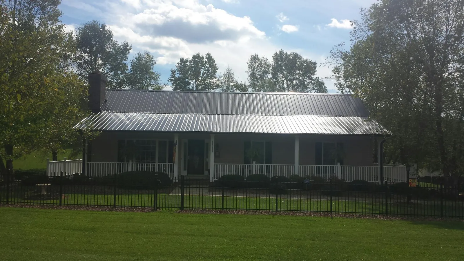 Gray metal roof on a brick ranch with a full width front porch — Gutter Guard Installation work by our crew in Sausalito
