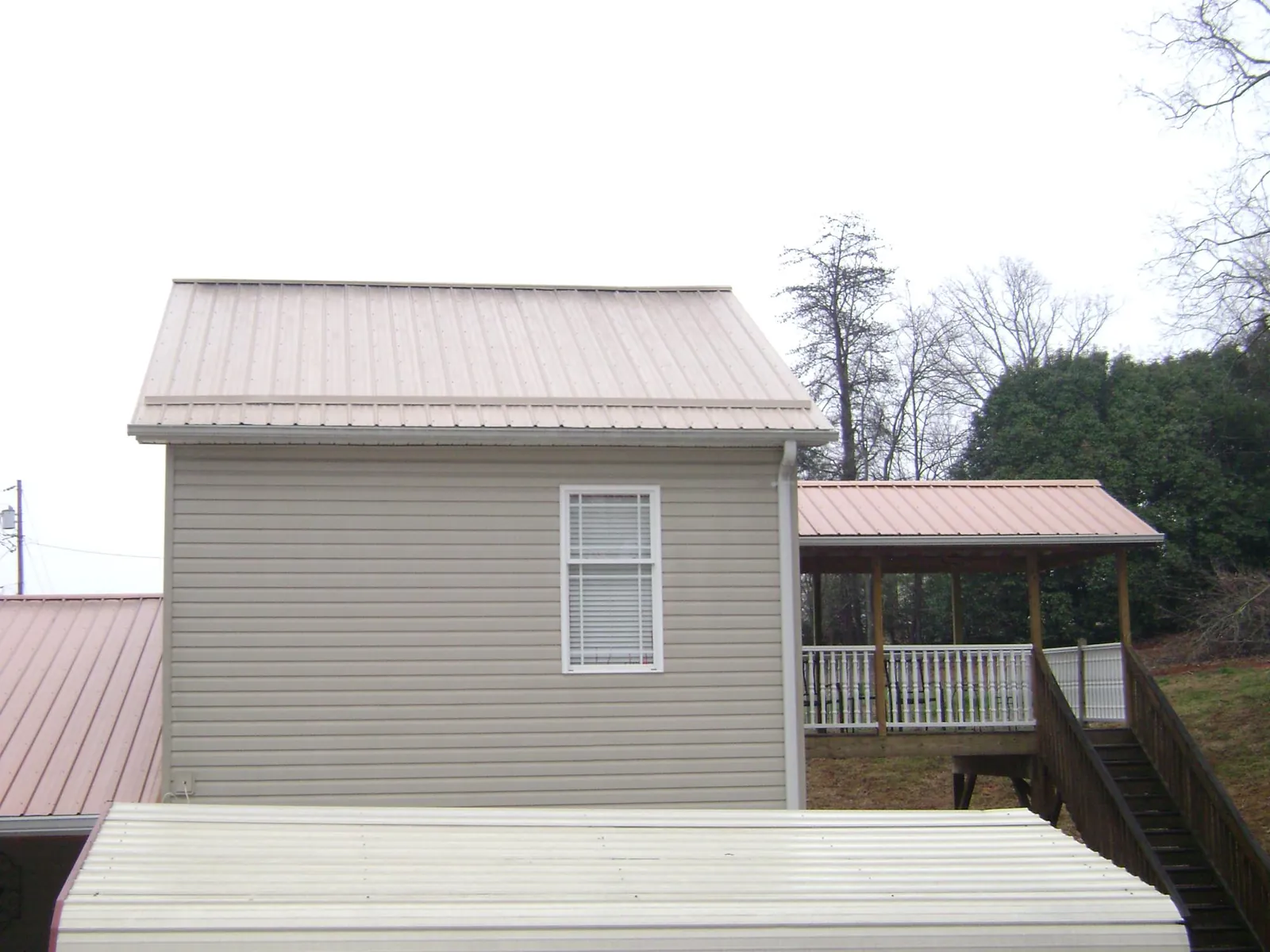 Tan metal roofs on a two story addition and attached porch, from a Roof Replacement job in Sausalito