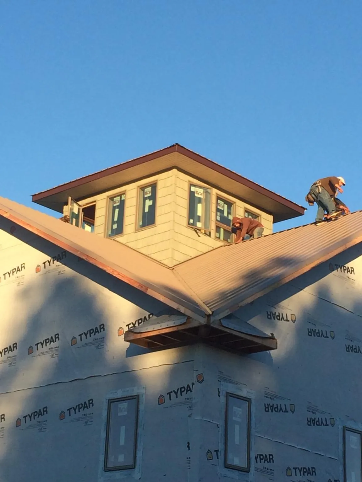 Roofers working around a rooftop cupola on a new metal roof at sunset — Roof Waterproofing in Sausalito by Roofing Brothers